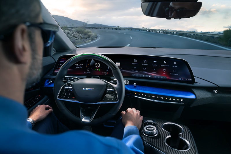 Front View of the 2026 OPTIQ-V Driving Through the Dusk Utilizing its Headlights | Cincinnati Cadillac in Cincinnati OH